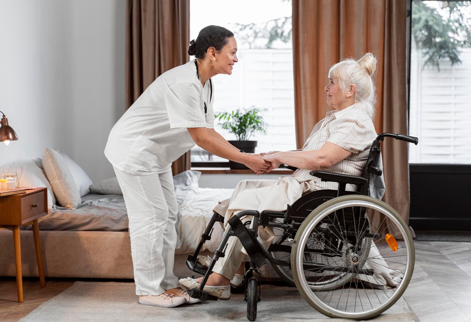 Friendly caregiver assisting an elderly resident in a wheelchair at Willows Care Home in Chester, ensuring compassionate and personalized care